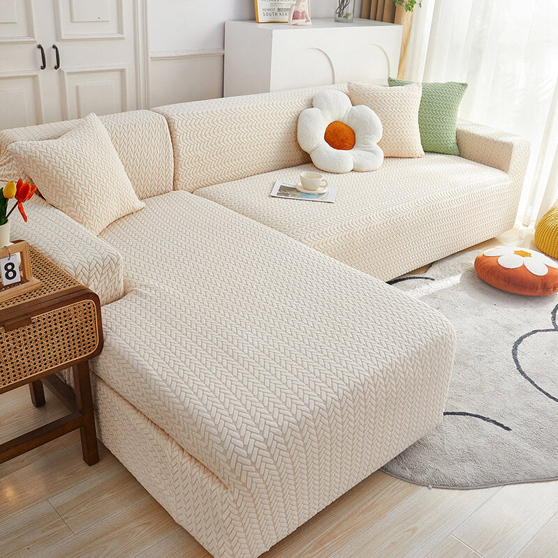 A beige sofa slipcover with a checkered design fitted on a sofa, accompanied by anti-slip foam rods, in a room setting with decorative items.